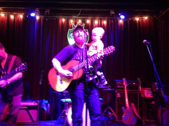 Luke Allen on stage with baby Arlo.